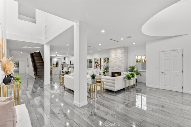 entrance foyer featuring recessed lighting, a large fireplace, baseboards, and stairs