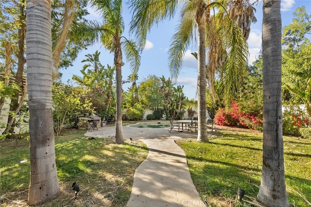 surrounding community featuring a lawn and a patio area