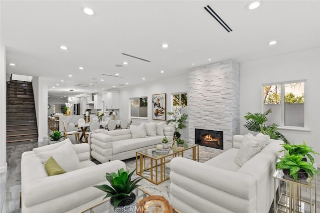 living room with recessed lighting, visible vents, a fireplace, and stairway