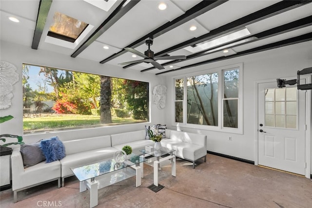 sunroom with a skylight, beam ceiling, and a ceiling fan