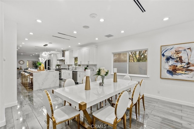 dining space featuring light wood finished floors, baseboards, visible vents, and recessed lighting