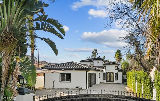 5157 Avenida Oriente, Tarzana, CA 91356 - rear view of house featuring stucco siding, a fenced front yard, a tiled roof, and a garage