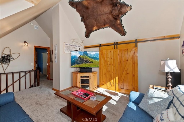 living room featuring lofted ceiling, a barn door, and carpet