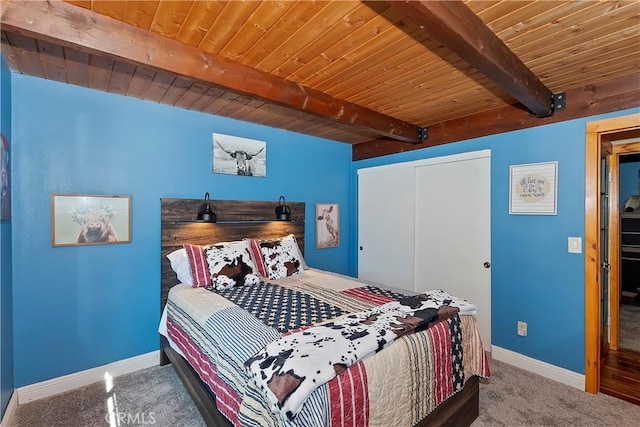 carpeted bedroom featuring wooden ceiling, a closet, and beam ceiling