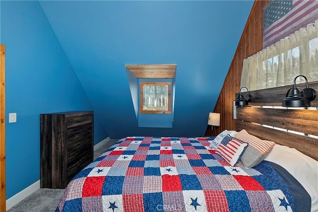 carpeted bedroom featuring lofted ceiling and wooden walls