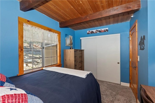 carpeted bedroom with wooden ceiling, a closet, and beamed ceiling