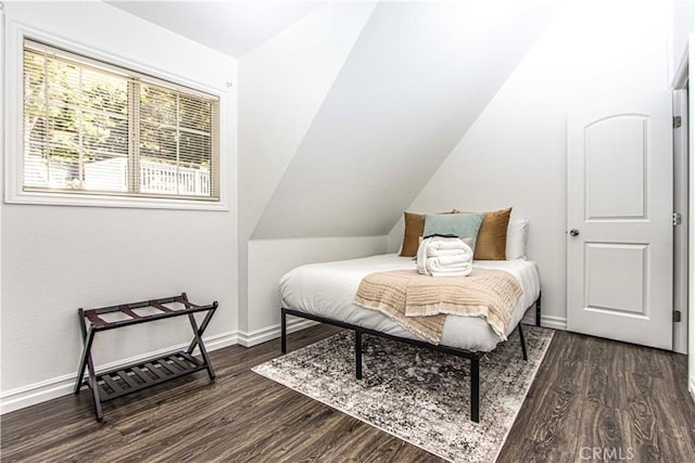 bedroom with dark wood-type flooring and lofted ceiling