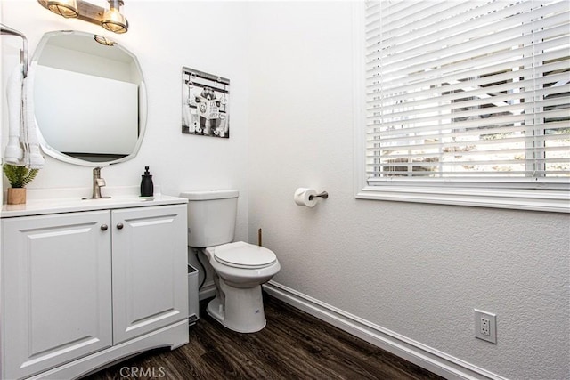 bathroom with wood-type flooring, vanity, and toilet