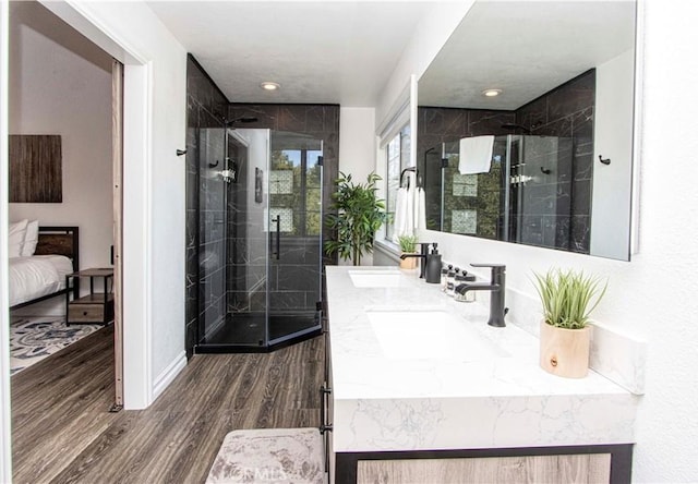 bathroom with hardwood / wood-style flooring, vanity, and walk in shower