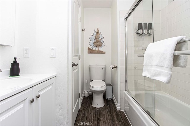 full bathroom with hardwood / wood-style floors, vanity, toilet, and enclosed tub / shower combo