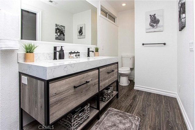 bathroom with vanity, wood-type flooring, and toilet