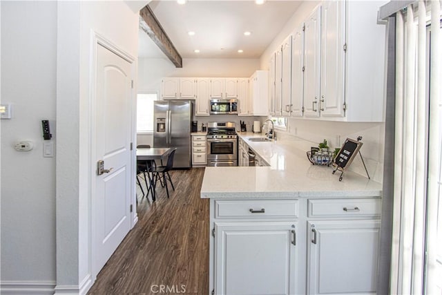 kitchen with white cabinets, beam ceiling, stainless steel appliances, and sink