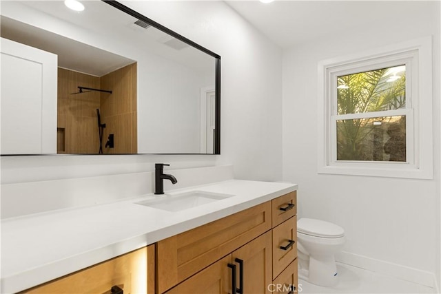 bathroom featuring vanity, toilet, and walk in shower