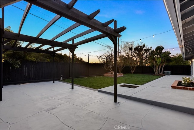 patio terrace at dusk featuring a pergola and a lawn