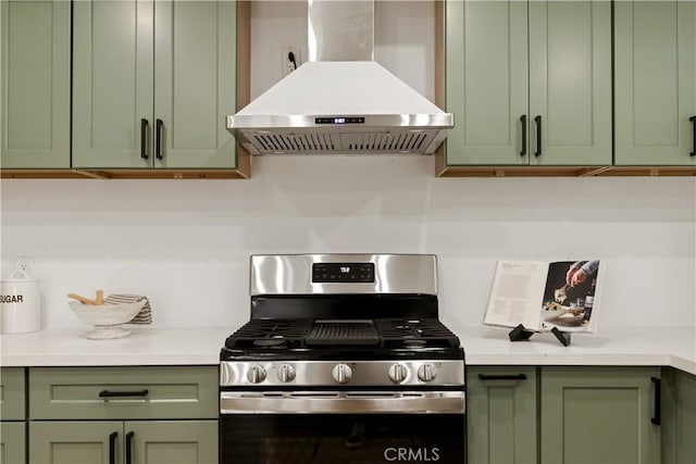 kitchen with green cabinetry, island range hood, and stainless steel range with gas stovetop