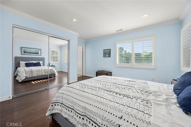 bedroom with dark wood-type flooring, a closet, and ornamental molding