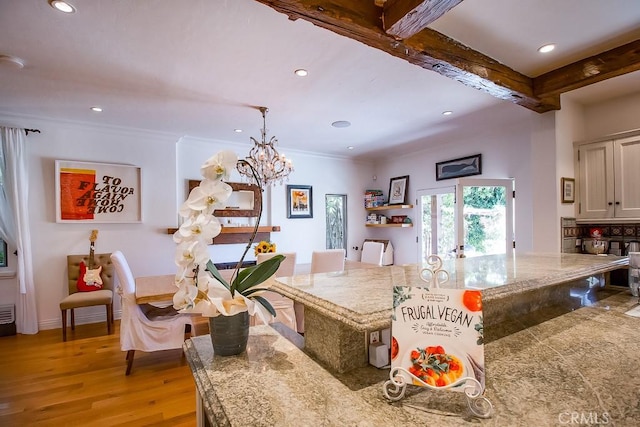 kitchen featuring ornamental molding, light wood-type flooring, an inviting chandelier, and beamed ceiling