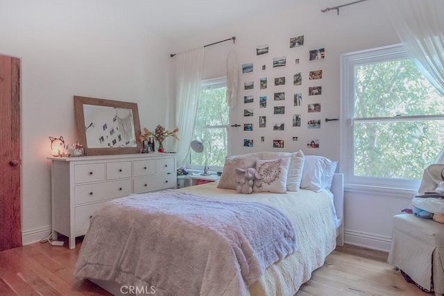 bedroom with light hardwood / wood-style flooring and multiple windows