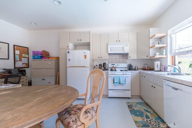 kitchen with white appliances, tile countertops, white cabinets, backsplash, and sink