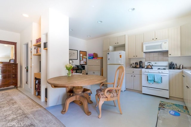 kitchen with white appliances, cream cabinetry, and tasteful backsplash