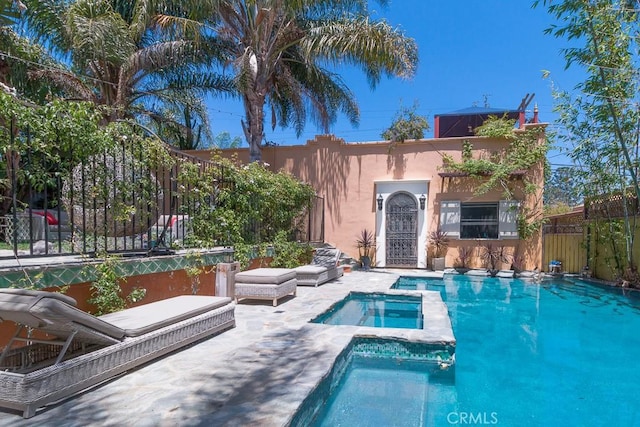 view of swimming pool with an in ground hot tub