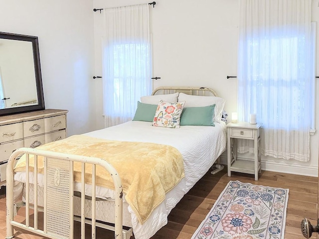 bedroom featuring dark wood-type flooring and multiple windows