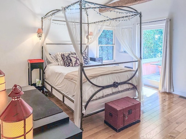 bedroom with wood-type flooring and access to exterior