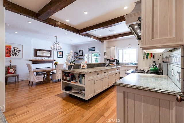 kitchen featuring a chandelier, light hardwood / wood-style floors, a center island, beam ceiling, and white cabinets