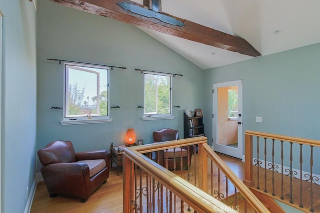 bedroom with light wood-type flooring, lofted ceiling with beams, and a crib