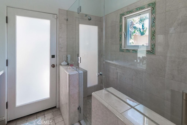 bathroom with a shower with door and a wealth of natural light