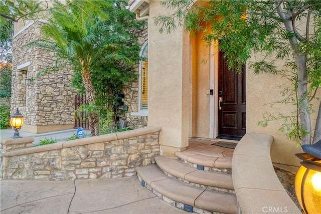 entrance to property with stone siding and stucco siding