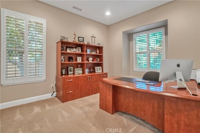 office space with visible vents, light colored carpet, and baseboards