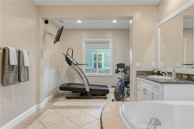 bathroom featuring recessed lighting, vanity, tiled tub, baseboards, and tile patterned flooring
