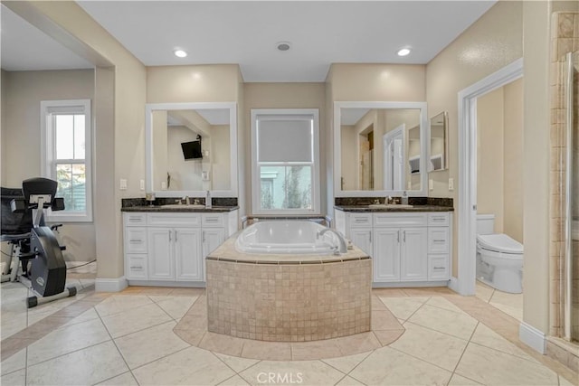bathroom with plenty of natural light, a bath, tile patterned flooring, and a sink