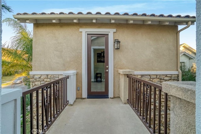 view of exterior entry with stucco siding and stone siding