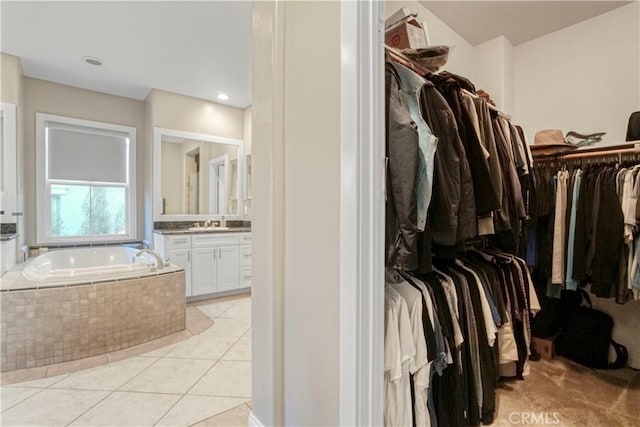 walk in closet featuring light tile patterned floors and a sink