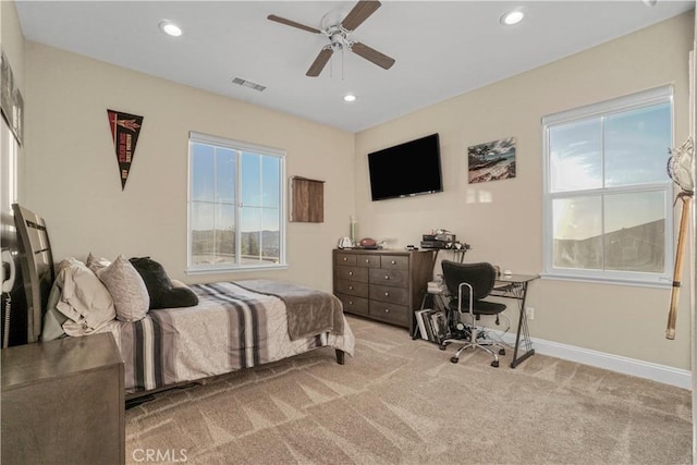 carpeted bedroom featuring visible vents, recessed lighting, and multiple windows