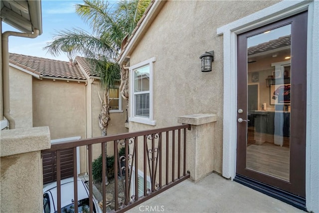 entrance to property with stucco siding and a balcony