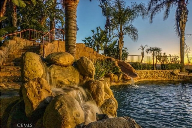 exterior space featuring a fenced in pool, a water slide, and fence