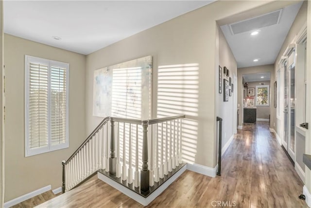 hallway with attic access, recessed lighting, an upstairs landing, baseboards, and wood finished floors