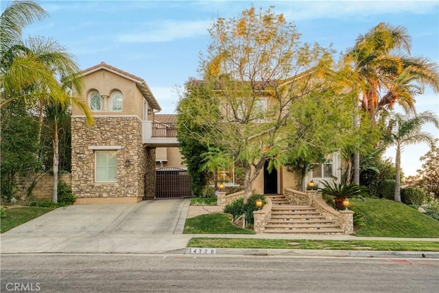 view of front of house with a tile roof, concrete driveway, stone siding, and stucco siding