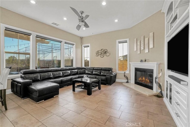 living area featuring ceiling fan, visible vents, baseboards, a glass covered fireplace, and recessed lighting