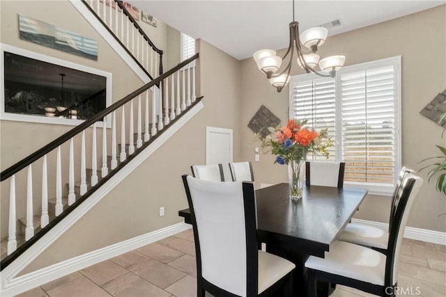dining area featuring an inviting chandelier, stairway, and baseboards