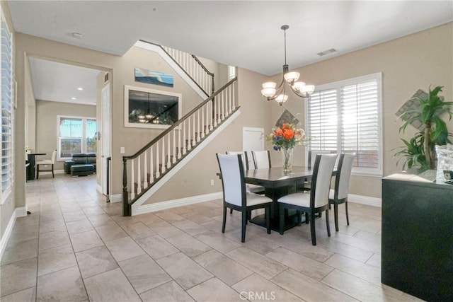 dining space with visible vents, a chandelier, stairs, and baseboards