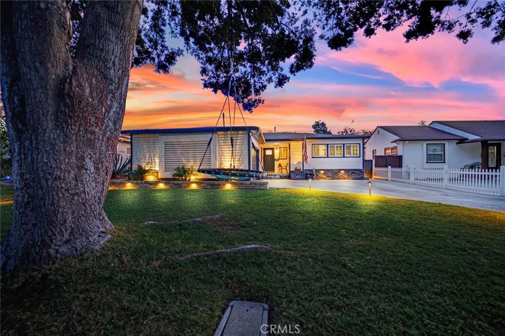 view of front of property featuring a lawn and a patio area