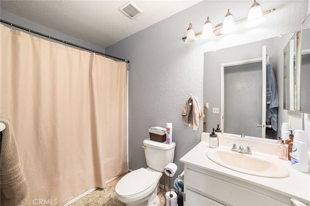 bathroom with walk in shower, vanity, a textured ceiling, and toilet