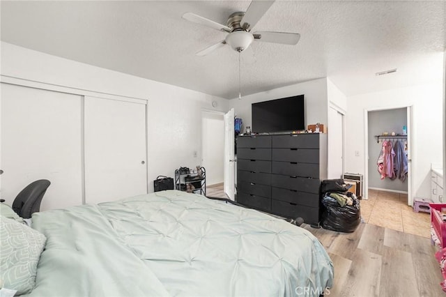 bedroom featuring ceiling fan, a textured ceiling, and light hardwood / wood-style flooring