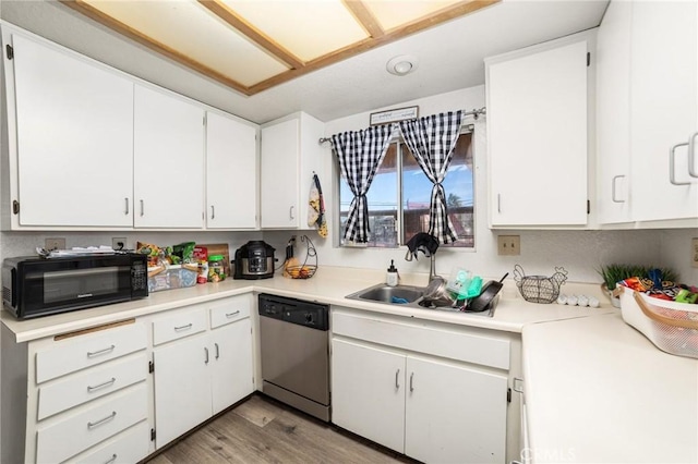 kitchen featuring light hardwood / wood-style flooring, white cabinets, stainless steel dishwasher, and sink