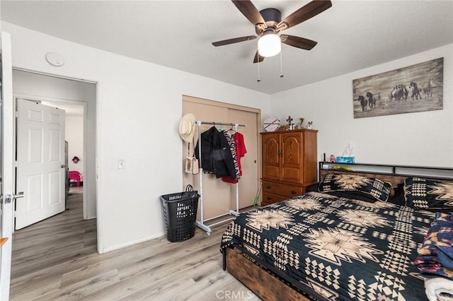 bedroom featuring ceiling fan, a closet, and light hardwood / wood-style floors