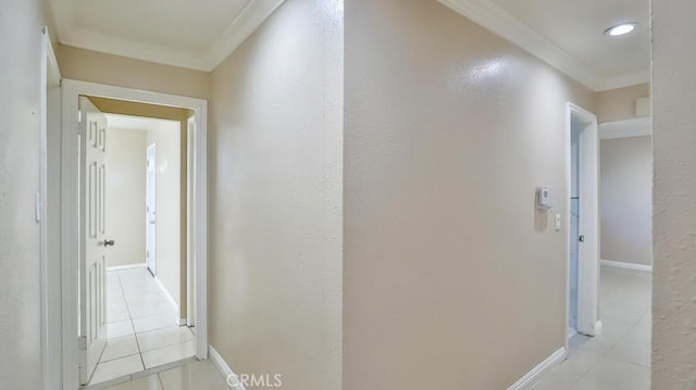 hallway with light tile patterned floors and crown molding